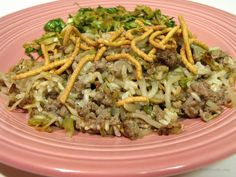 a pink plate topped with lots of food