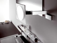 a bathroom sink with a round mirror above it