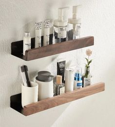 two wooden shelves holding different types of personal care items on them, one shelf is mounted to the wall