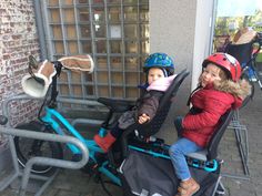 two children in helmets are sitting on bicycles