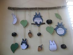 a wall hanging with many different kinds of animals on it's sides and leaves attached to the strings