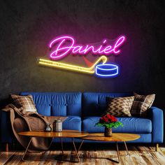 a living room with a couch, table and neon sign on the wall above it