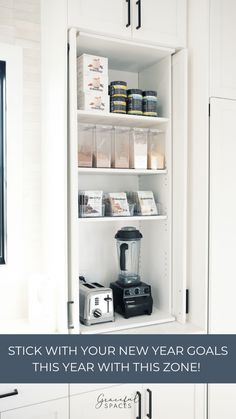 a kitchen with white cupboards and shelves filled with items that include blenders, juicers, and more