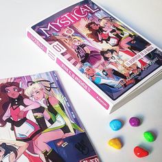 two books with candy candies next to them on a white surface, one has an image of cartoon characters