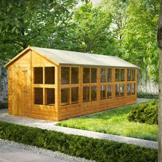 a small wooden building sitting in the middle of a lush green park