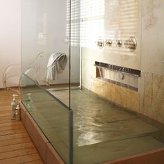 a bathroom with glass walls and wooden floors