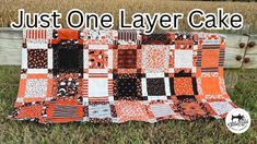 an orange and black patchwork quilt sitting on top of grass with the words just one layer cake