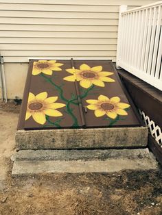 the painted sunflowers are on top of the concrete steps in front of the house