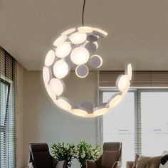 a living room filled with furniture and a large circular light fixture hanging from the ceiling