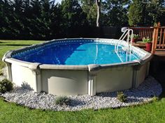 an above ground swimming pool in the middle of a yard with gravel and rocks around it