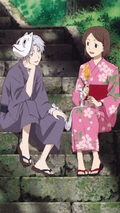 two women in kimonos sitting on steps with one holding a flower and the other looking at something