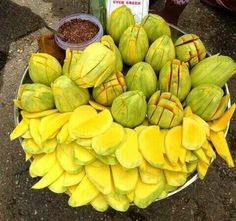 a bunch of bananas on a plate with some chili sauce in the bowl next to it