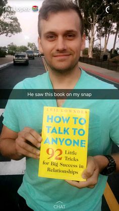 a man holding up a yellow book in his left hand with the caption he saw this book on my snap