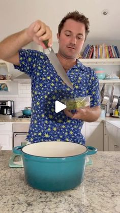 a man in a blue shirt is holding a knife and cutting food into a bowl