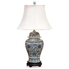 a blue and white vase with a lamp on it