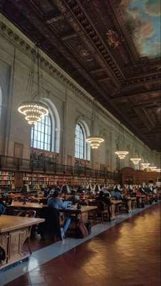 people are sitting at tables in the library