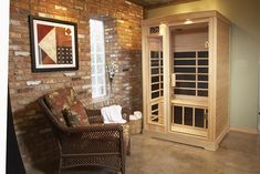 a living room with a chair and a sauna in the corner next to a brick wall