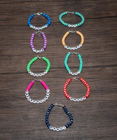 six different colored bracelets on a wooden table