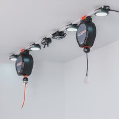 three spotlights are attached to the ceiling in a room with white walls and flooring