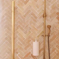 a bathroom with a gold faucet and tiled walls