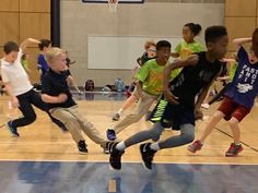 young boys playing basketball on an indoor court