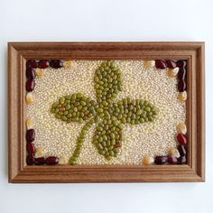 an art work made with beads and other things in a wooden frame on the wall