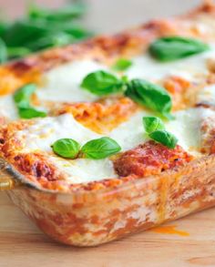 a casserole dish with cheese and spinach leaves on the side, ready to be eaten