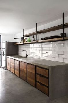 an industrial style kitchen with wooden cabinets and shelves