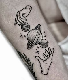 an arm tattoo with two hands reaching for the planets and stars on it, while another hand reaches out to touch the planet