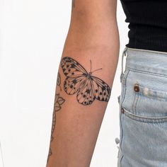 a woman's arm with a butterfly tattoo on the left side of her arm