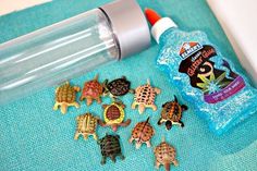 several small turtle toys next to a bottle of deodorant on a towel