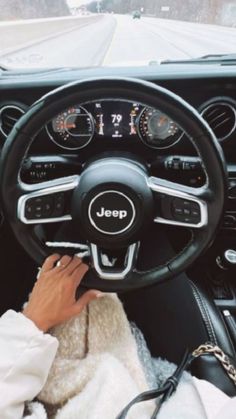 a person driving a car with the steering wheel up and hands on the dash board