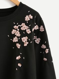 a black sweatshirt with pink flowers on it