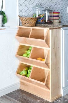 a wooden shelf filled with apples and other fruit on top of a kitchen counter next to a