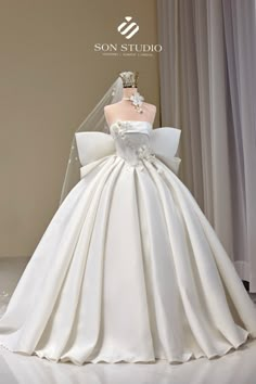 a white wedding dress on display in front of a window