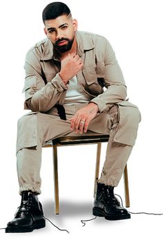 a man sitting on top of a chair with his hand under his chin and looking at the camera