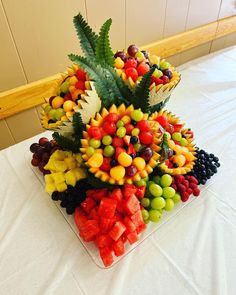 a bunch of fruit sitting on top of a table next to a white table cloth