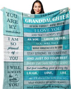 a woman is holding up a blanket with the words granddaughter on it and an image of her