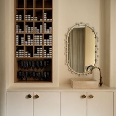 a bathroom with white cabinets and a large mirror on the wall next to a sink