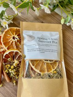 a bag of orange slices sitting on top of a wooden table next to some flowers