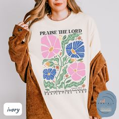 a woman wearing a t - shirt that says praise the lord with flowers on it