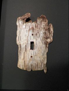 a piece of wood that has been carved into the shape of a house with two windows