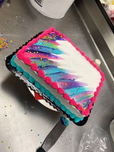 a cake that is sitting on top of a metal table with confetti sprinkles