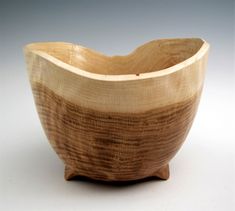 a wooden bowl sitting on top of a white table