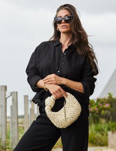 This hobo bag is woven from raffia and then hand embroidered with over 100 faux baroque pearls and trimmed in metallic leather. The knotted bow accent is fun and feminine, while still being elevated and modern. Stow your phone and keys inside and slip it over your wrist for easy carrying. VOGUE calls The Josie Knot Bag one of "The Very Best Raffia Bags to Carry You Through the Summer in Style." POOLSIDE bags are handwoven by female artisans in The Philippines, India, Morocco, and Spain, using na Chic Pouch Bag With Bamboo Handle, Chic Evening Straw Bag, Woven Straw Bag As Fashion Accessory, Chic Shoulder Bag With Bamboo Handle, Elegant Straw Bag With Bamboo Handle, Chic Straw Bag With Bamboo Handle, Chic Handwoven Shoulder Bag For Evening, Elegant Woven Shoulder Bag With Round Handle, Chic Handwoven Evening Shoulder Bag