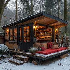 a red couch sitting in the middle of a snow covered yard next to a tree