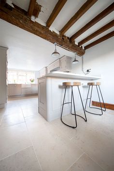 two bar stools sit in the middle of a kitchen