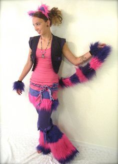 a woman in pink and purple costume standing next to a wall with her hands on her hips