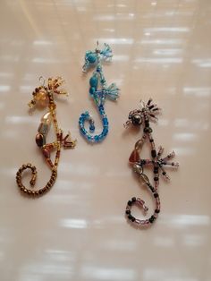 three different types of seahorses on a white surface, one is blue and the other is gold