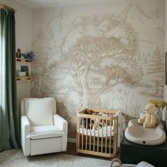 a baby's room with a chair, crib and wallpaper